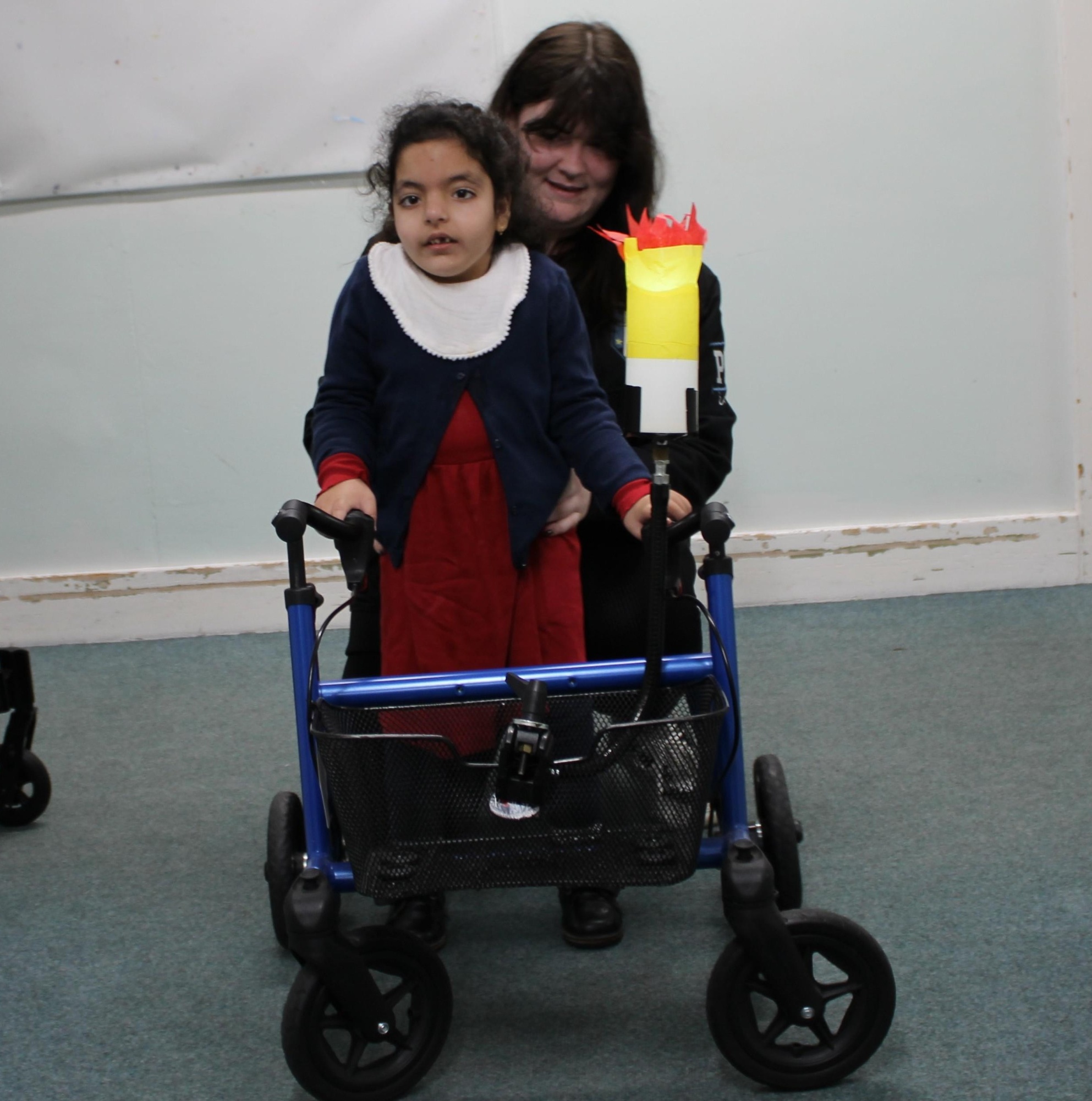 Pupil using a walking frame to deliver the Olympic torch 