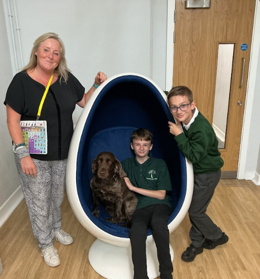Pupils sitting with canine assisted learning dog