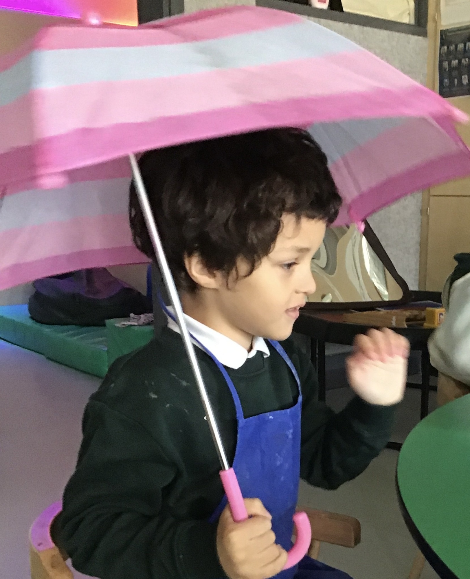 Pupil sitting under an umbrella 