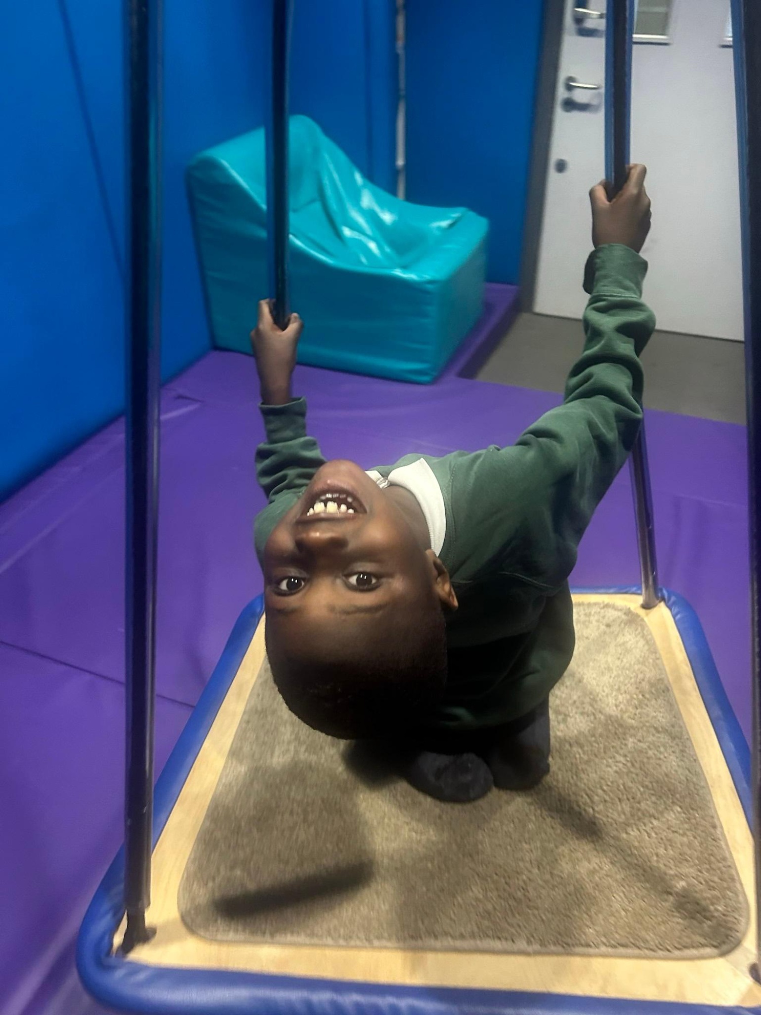 Pupil using swing in sensory room