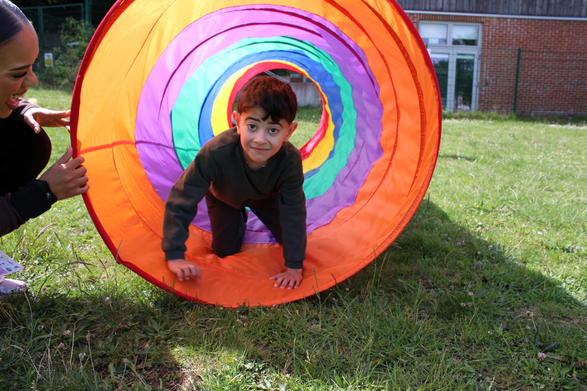 Pupil climbing through colourful tunnel 