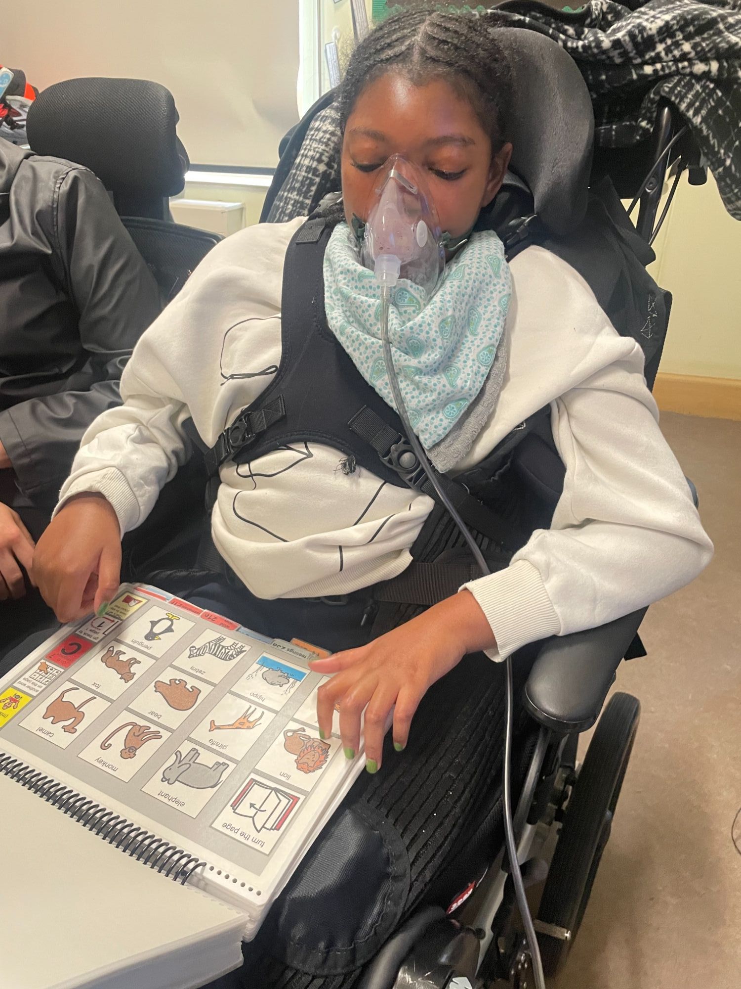 Pupil in a wheelchair looking at a symbol chart
