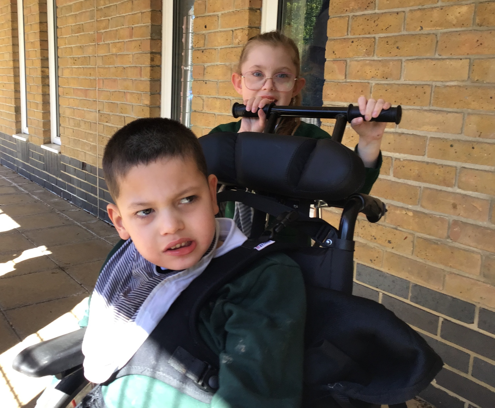 Pupil pushing another pupil in a wheelchair 